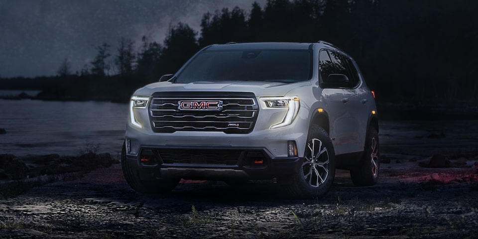 Front-side view of the 2024 GMC Acadia AT4 with a unique grille and badging.