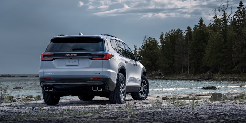 Back view of the 2024 GMC Acadia AT4 parked by the beach.