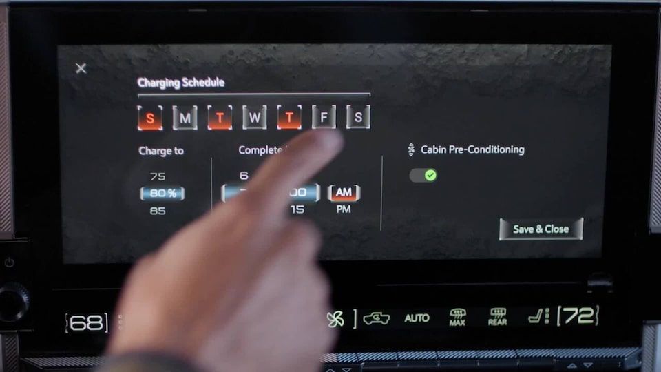 Close-Up of a Person Choosing Their 2025 Hummer EV Charging Schedule at Home Through the Infotainment Screen