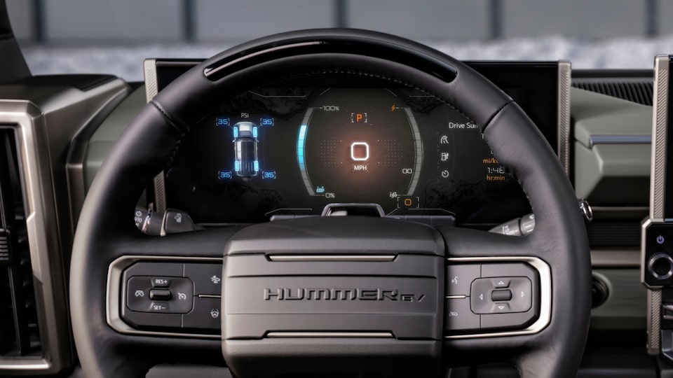 Driver’s view of the steering wheel and speedometer dashboard for the 2025 GMC Hummer EV SUV.