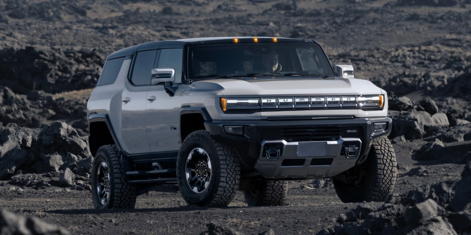 Three-quarter view of a 2025 GMC Hummer EV SUV on a rocky plain.