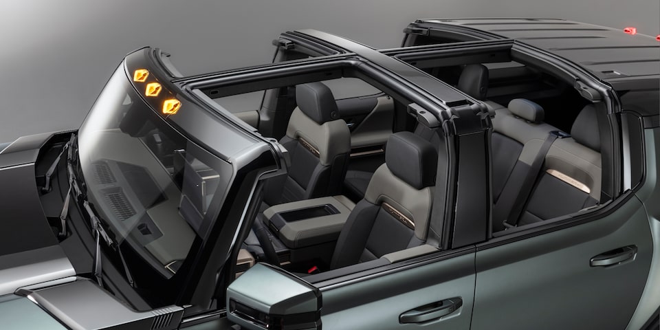 Over the head three quarters view of a 2025 GMC Hummer EV SUV with Its sunroof opened.