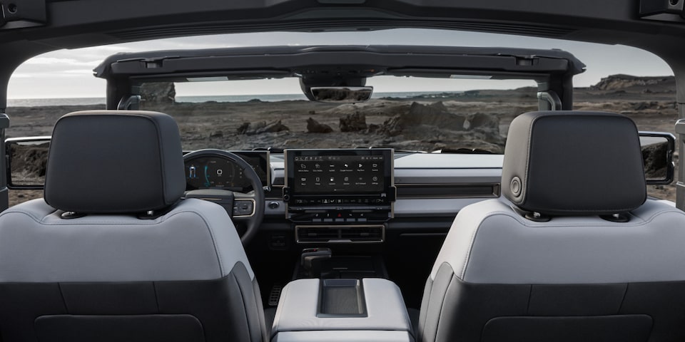 Passenger seat view of a 2025 GMC Hummer EV SUV on a rocky plain.