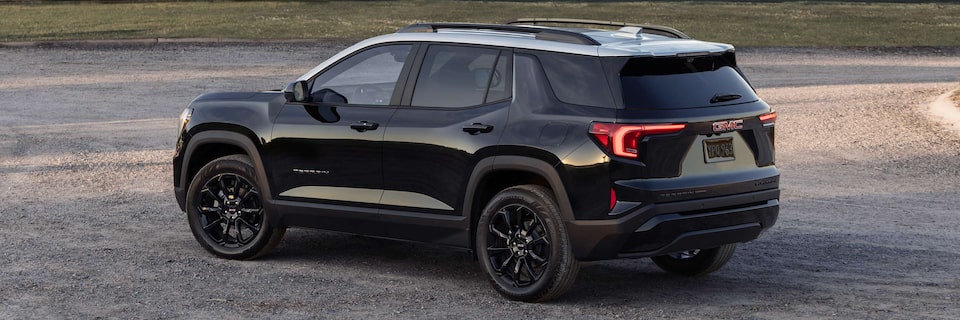 Back-side view of the 2025 GMC Terrain parked alone outdoors.