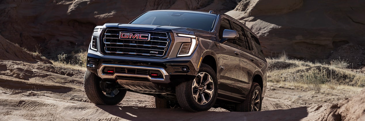 2025 GMC Yukon driving on a canyon on a sunny day.