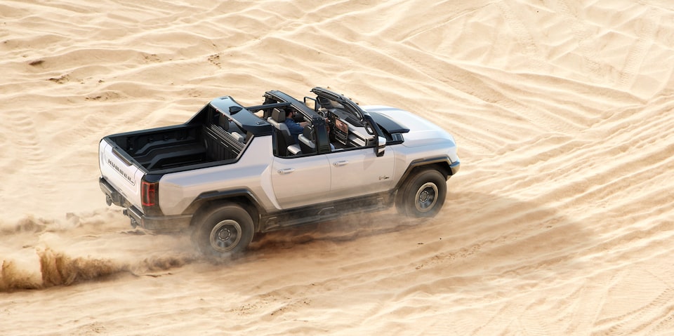 Overhead side view of the GMC Hummer EV Pickup with Transparent Sky Panels while driving in the desert.