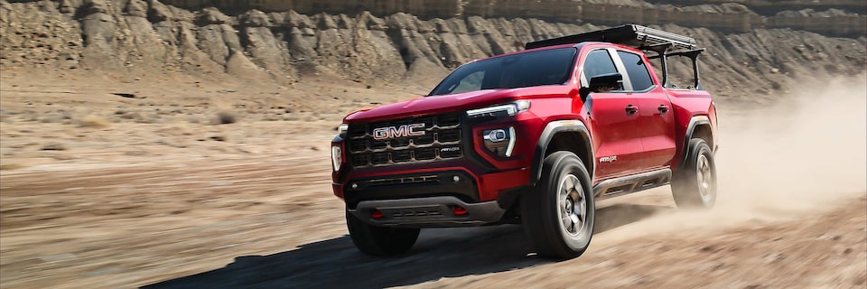 2025 GMC Canyon AT4 off-roading in a dusty terrain.