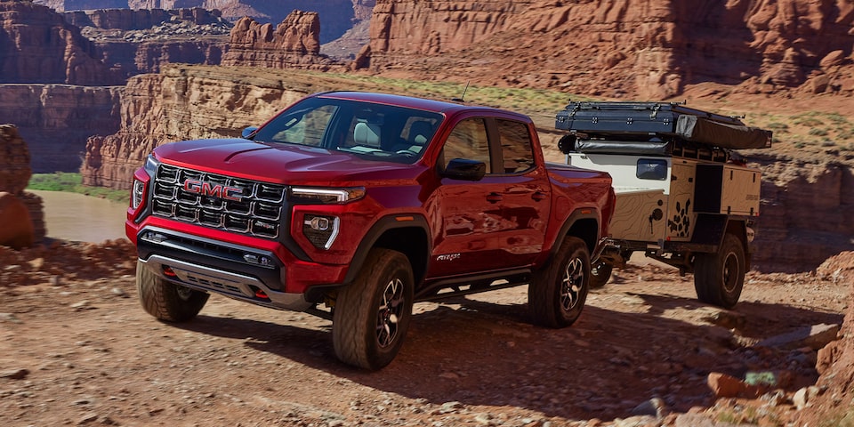 A 2025 GMC Canyon towing a trailer in a canyon landscape.