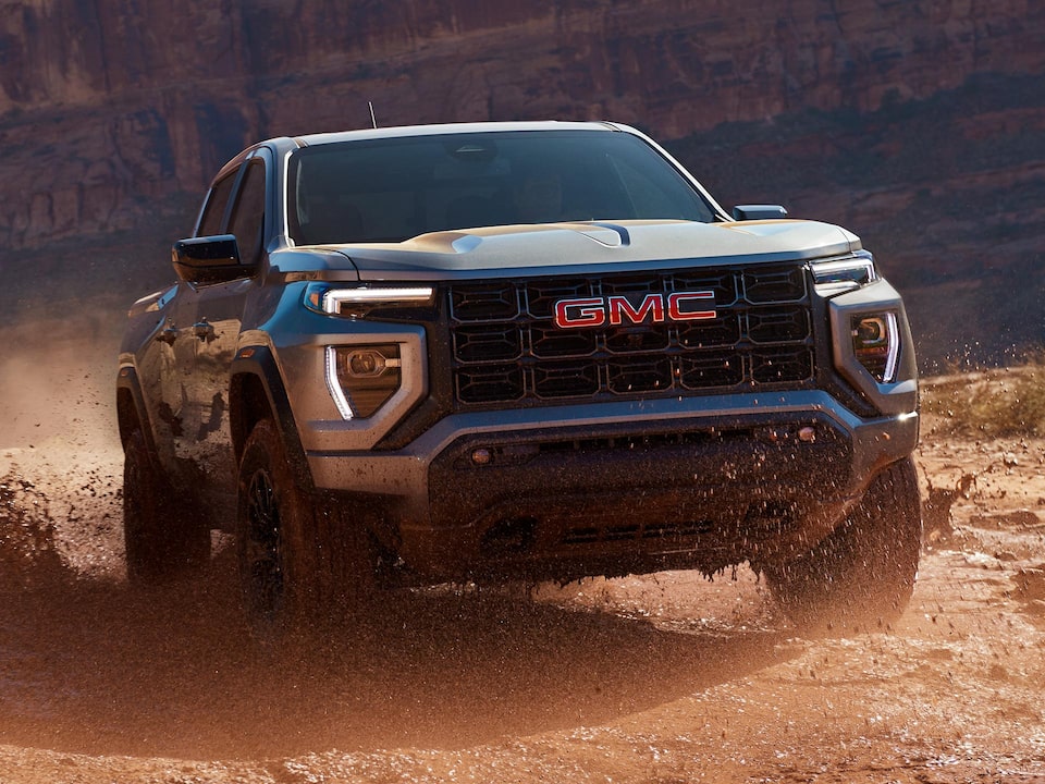 Three-quarters View of the 2025 GMC Canyon Truck Driving Through the Desert alone.