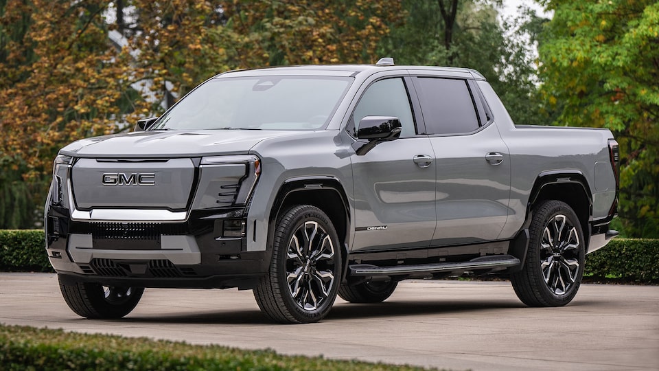 Front-side view of the 2025 GMC Sierra EV Denali parked near trees.