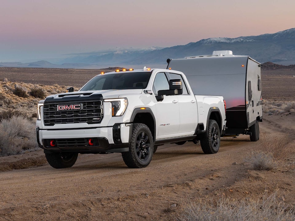 2025 GMC Sierra HD AT4 Truck hauling a trailer through the desert.