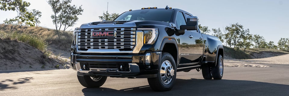 Front-side view of a 2025 GMC Sierra HD Denali Truck Driving on an Open Road.