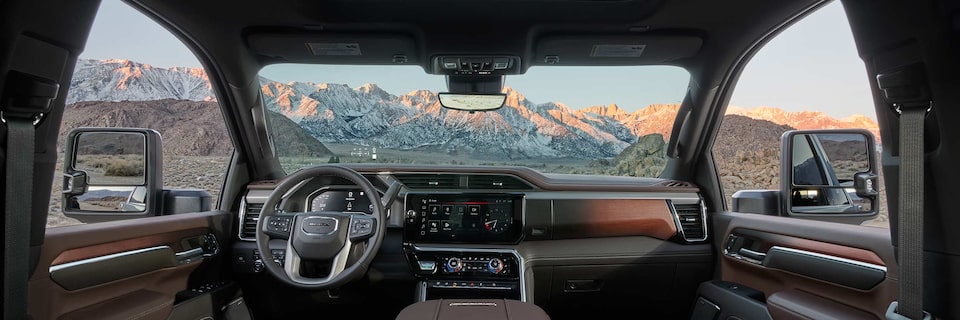 Wide Interior View of a 2025 GMC Sierra HD Denali Truck parked in a mountain area.