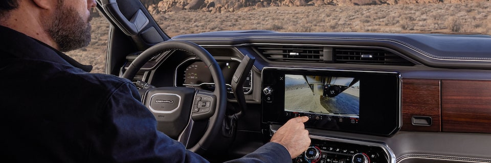 A Driver Switching the Camera Views on the Infotainment Screen of a 2025 GMC Sierra HD Denali Truck