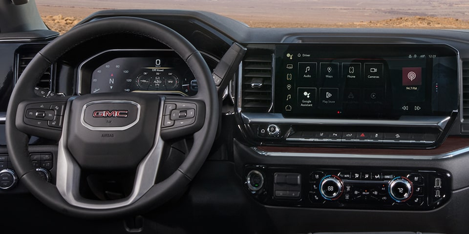 Vue rapprochée du volant, du tableau de bord numérique et du système d’infodivertissement du camion GMC Sierra HD Pro/SLE/SLT 2025.