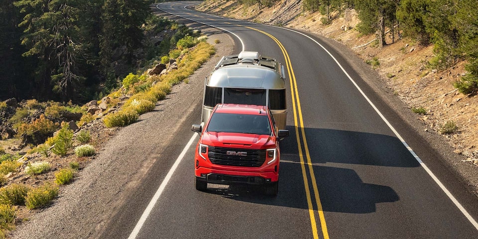 Birds-eye View of a Sierra 1500 Pulling an Airstream Trailer Down the Open Road