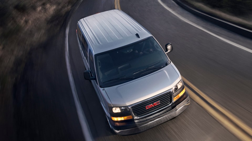 GMC Savana Passenger driving with headlamps on.