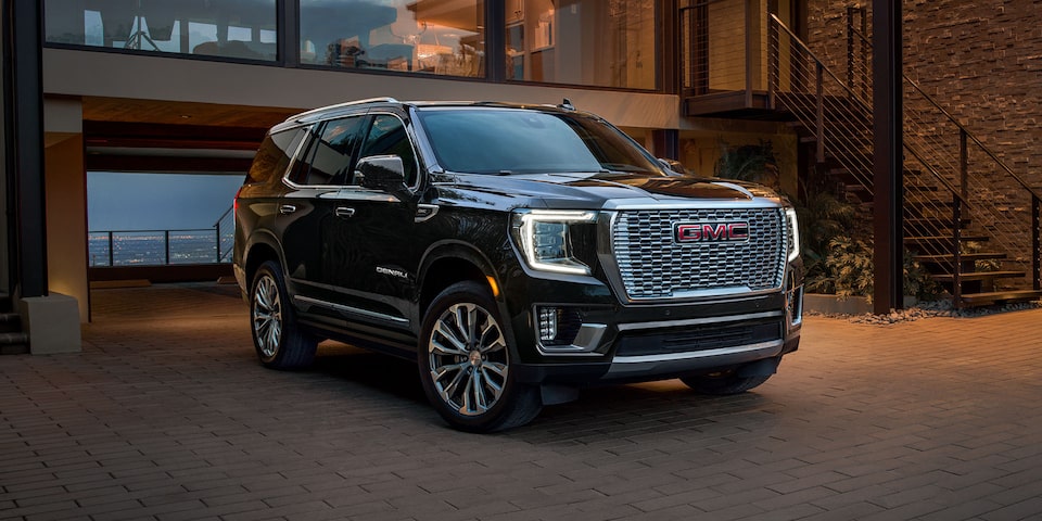 2024 GMC Yukon Denali exiting a modern home.