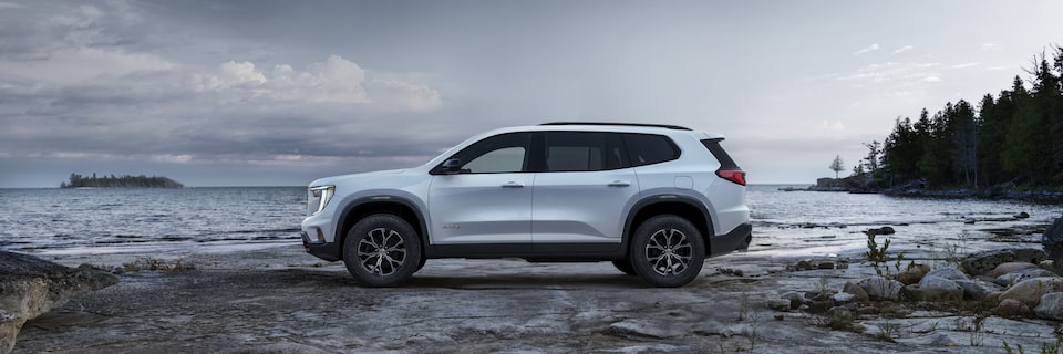 Side view of the 2025 GMC Acadia AT4 parked by the beach.