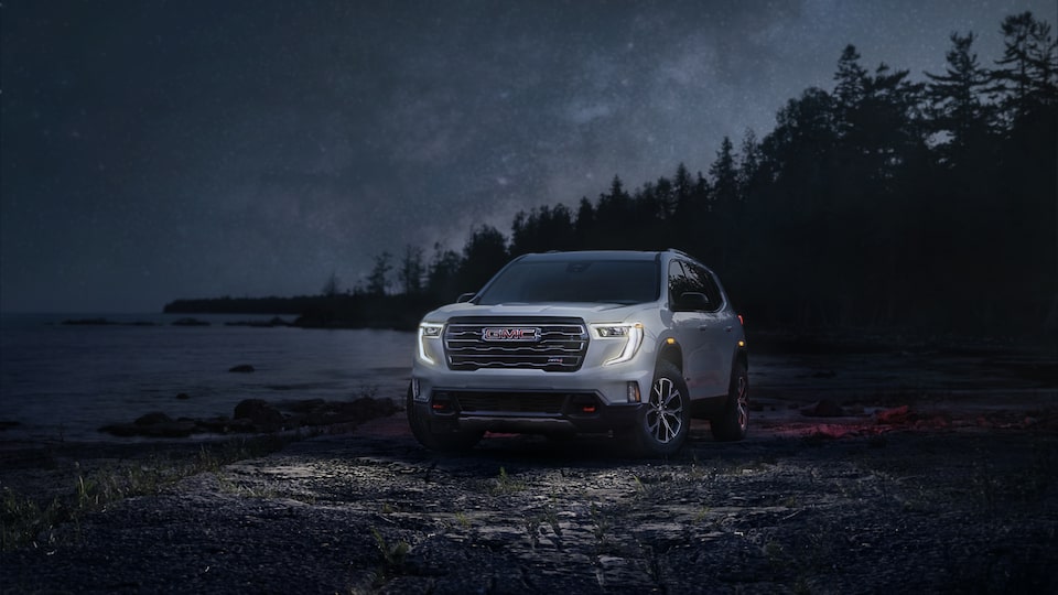 Le GMC Acadia AT4 2025 stationné seul la nuit.