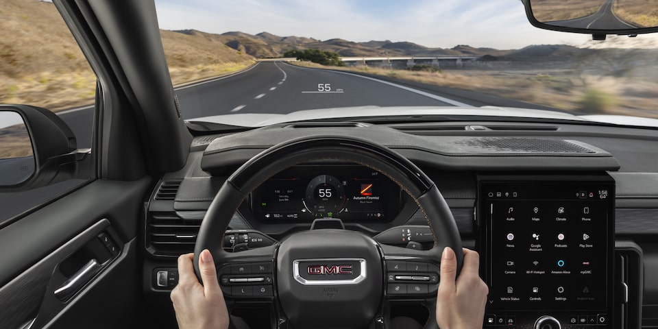 Driver's view of holding the steering wheel on the 2025 GMC Acadia Denali.