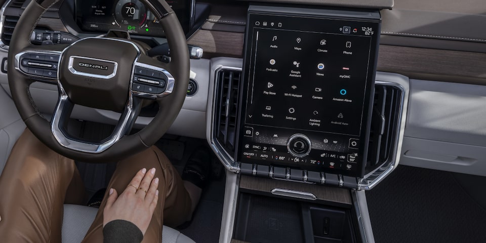 A person seated at the driver's seat of the 2025 GMC Acadia Denali.