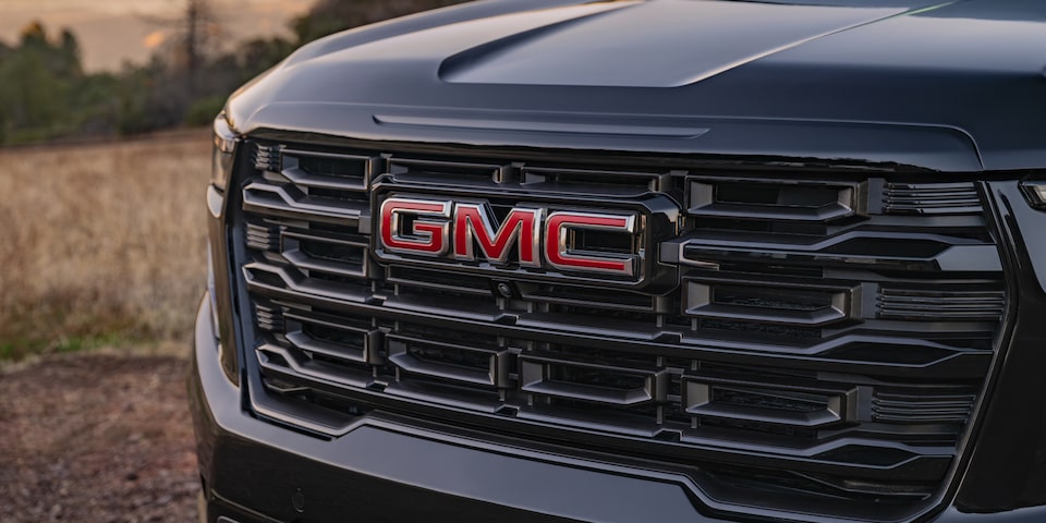 Close up view of the GMC logo being etched on the grille of the 2025 GMC Acadia Elevation.