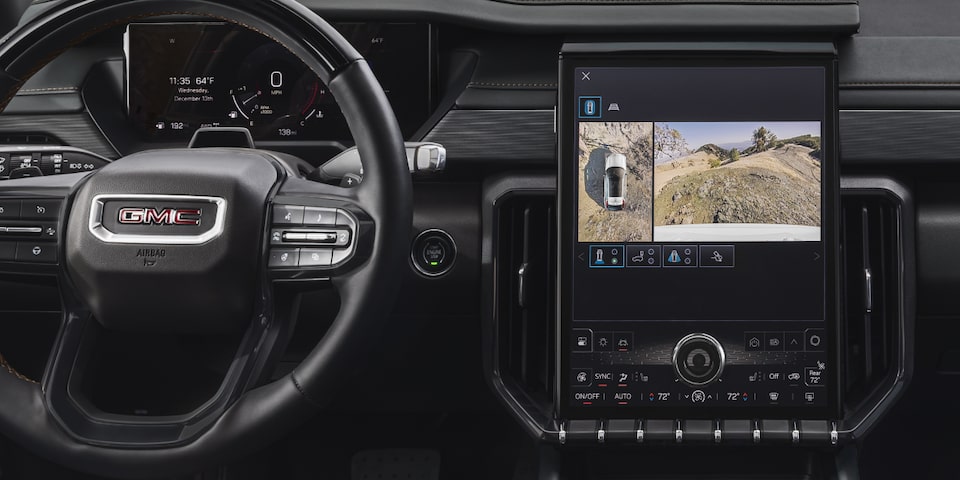 Front view of the front interiors of the 2025 Acadia with a camera view open in the infotainment screen.