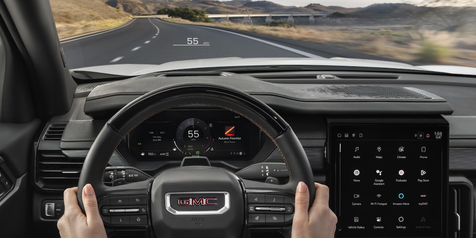 Driver's view of manning the steering wheel inside the 2025 GMC Acadia.