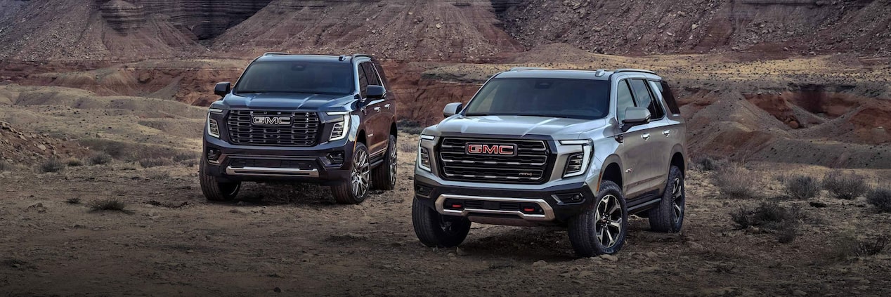 The 2025 GMC Yukon and Yukon XL SUVs parked near a canyon.