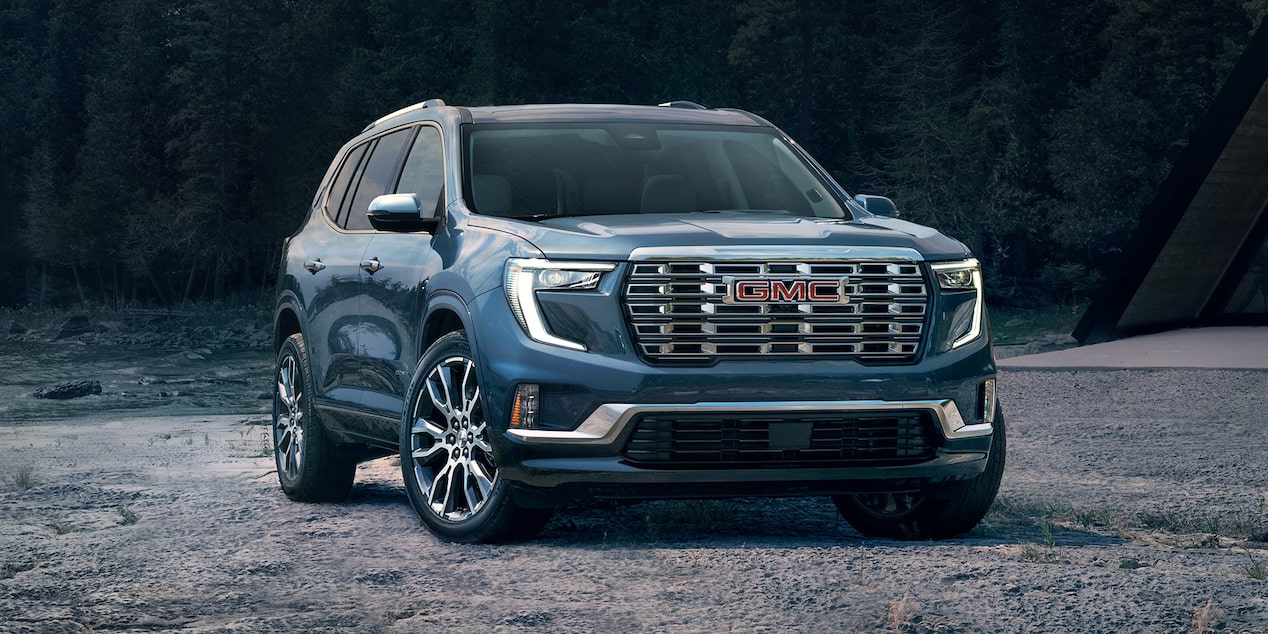 Front-side view of the GMC Acadia Mid-Size SUV parked on the beach.
