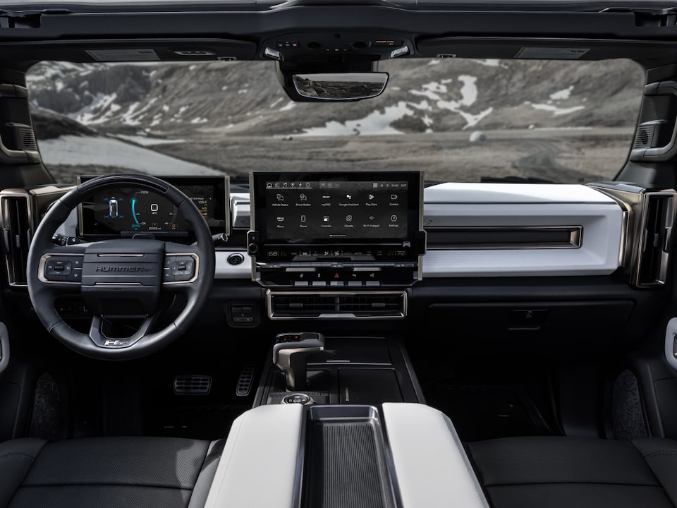 Front interior view of the 2025 GMC Hummer EV Sleek Dashboard and Advanced Infotainment System overlooking the mountains.