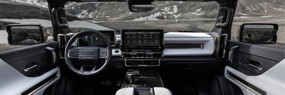 Back seat view of the 2025 GMC Hummer EV Sleek Dashboard and Advanced Infotainment System overlooking the mountains.