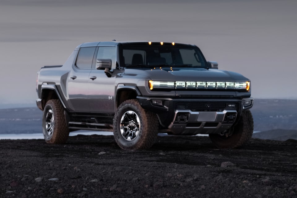 Three-quarters view of the 2025 GMC Hummer EV Pickup Truck parked under an evening sky.