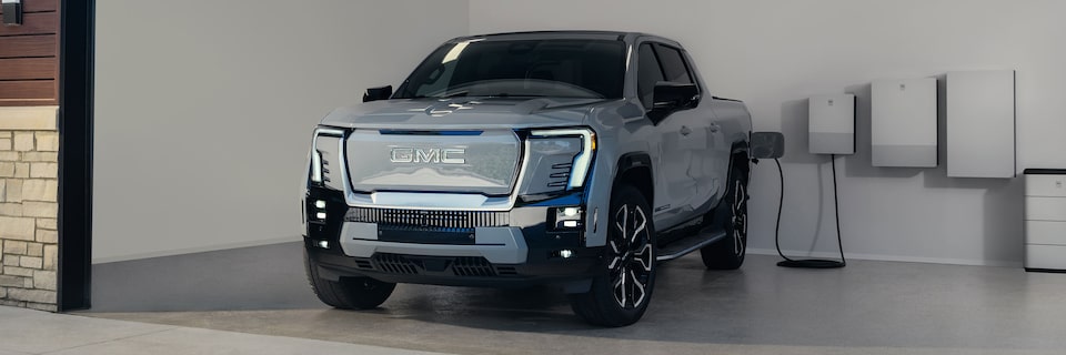 Front-side view of the 2025 GMC Sierra EV Denali being EV charged.