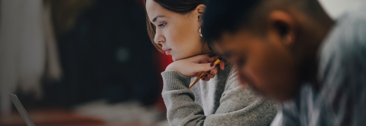 Two people concentrating on their tasks eligible for GM's Student Bonus Program.