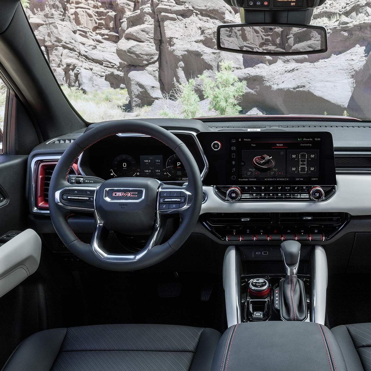 Driver's view of the steering wheel and infotainment screen in the GMC Canyon Pickup Truck.