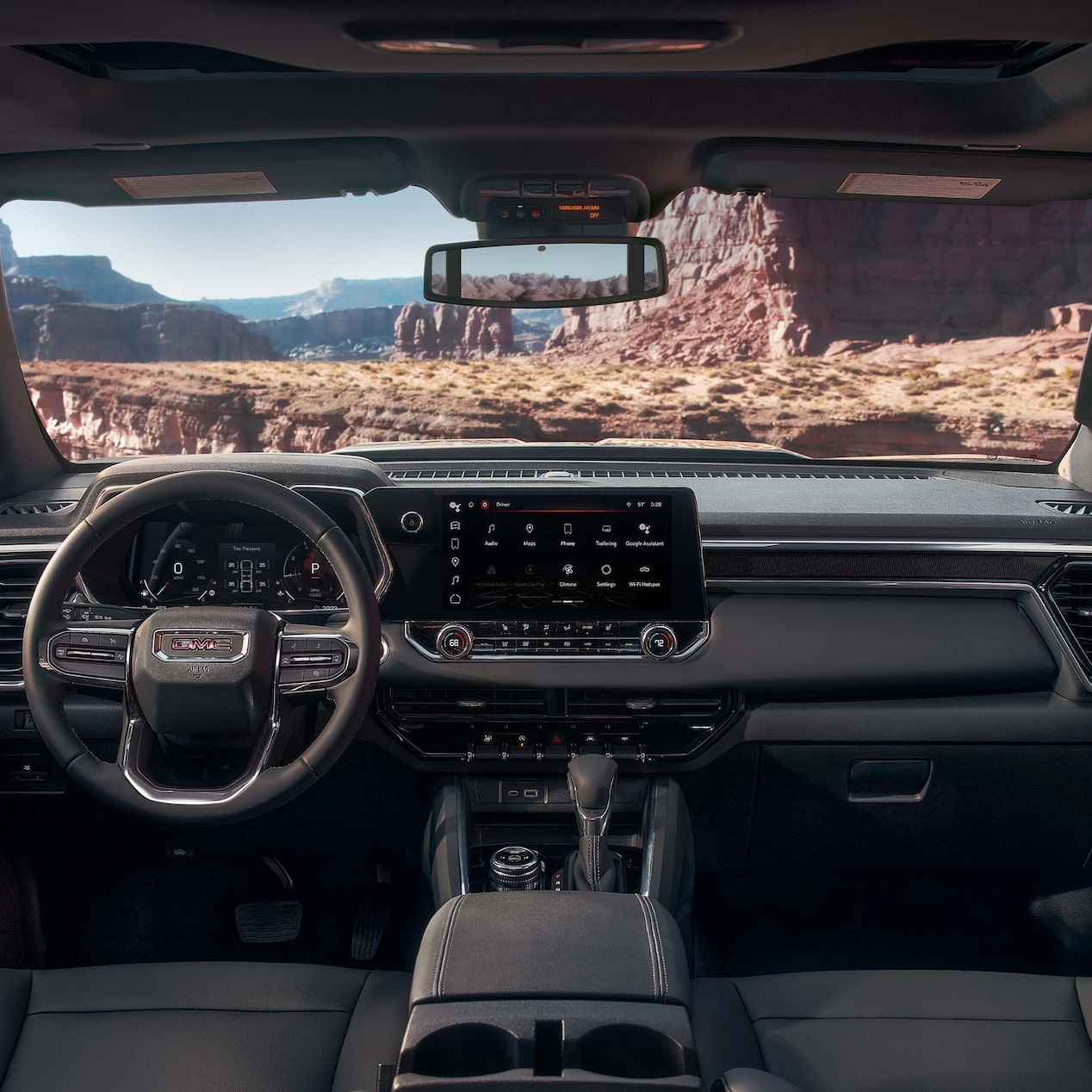 Front view of the interiors of the 2024 GMC Canyon overlooking a canyon.