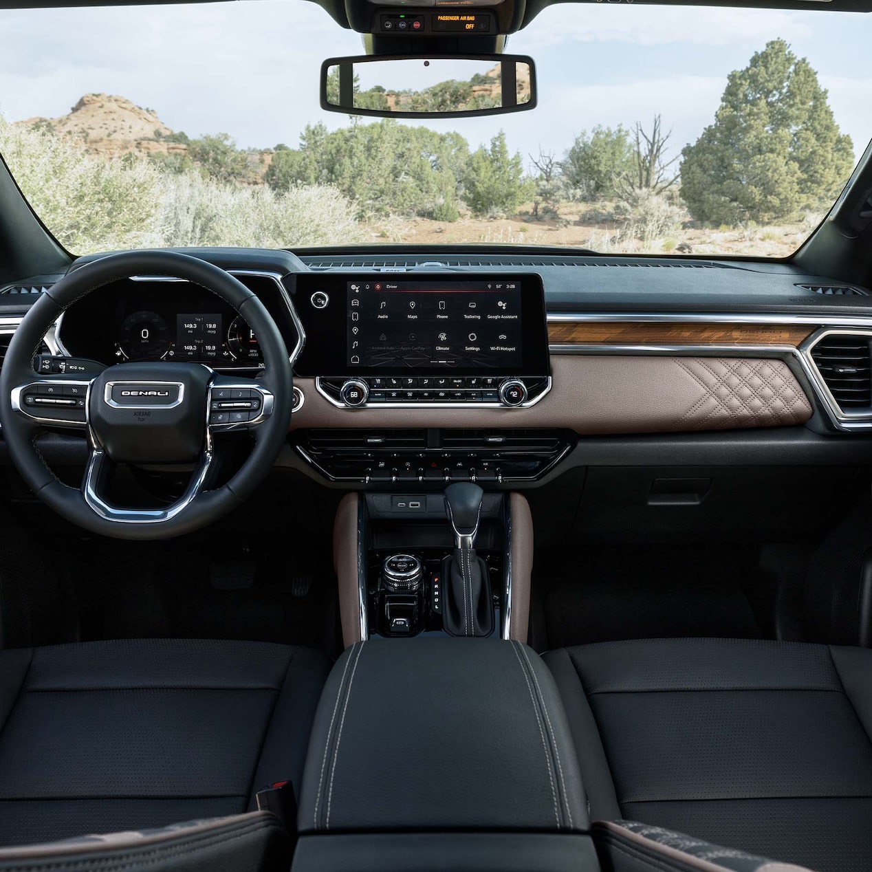 Front view of the interiors of the 2024 GMC Canyon overlooking a forest.