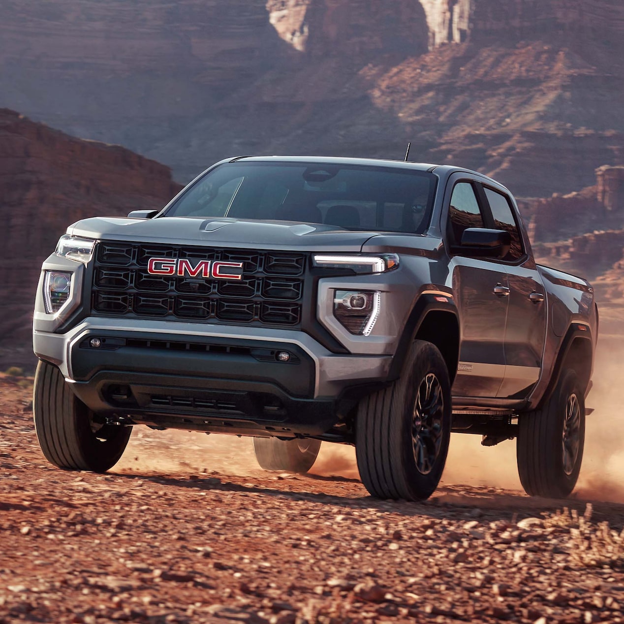 2024 GMC Canyon Elevation driving on a dusty canyon.