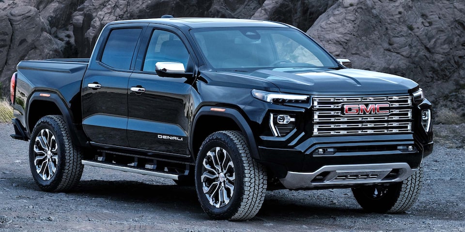 Front-side view of the 2025 GMC Canyon Denali driving near a cliff.