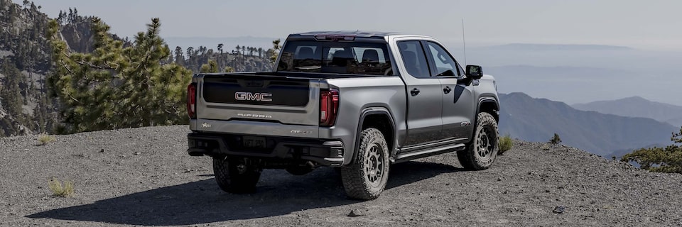 Rear View of the 2025 GMC Sierra AT4 Parked on an Off-Road Trail Over Looking the Mountains