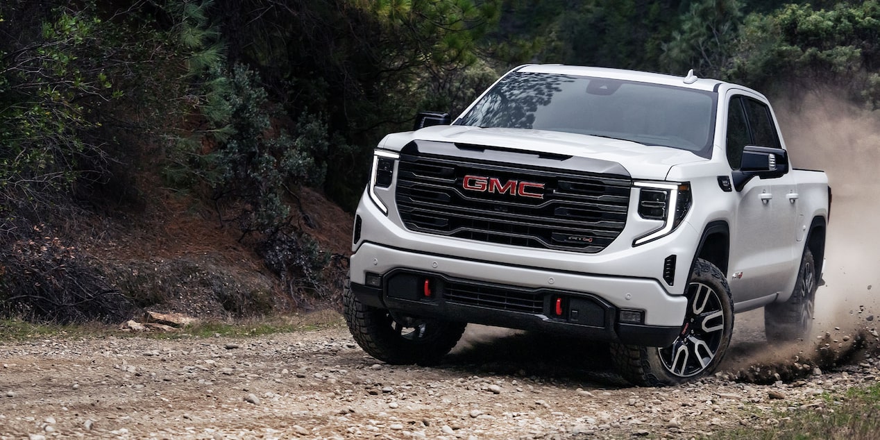 Le GMC Sierra 1500 AT4 2024 en mouvement sur une route au bord de la mer.