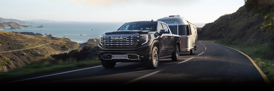 The GMC Sierra HD Driving On-Road Towing a Trailer