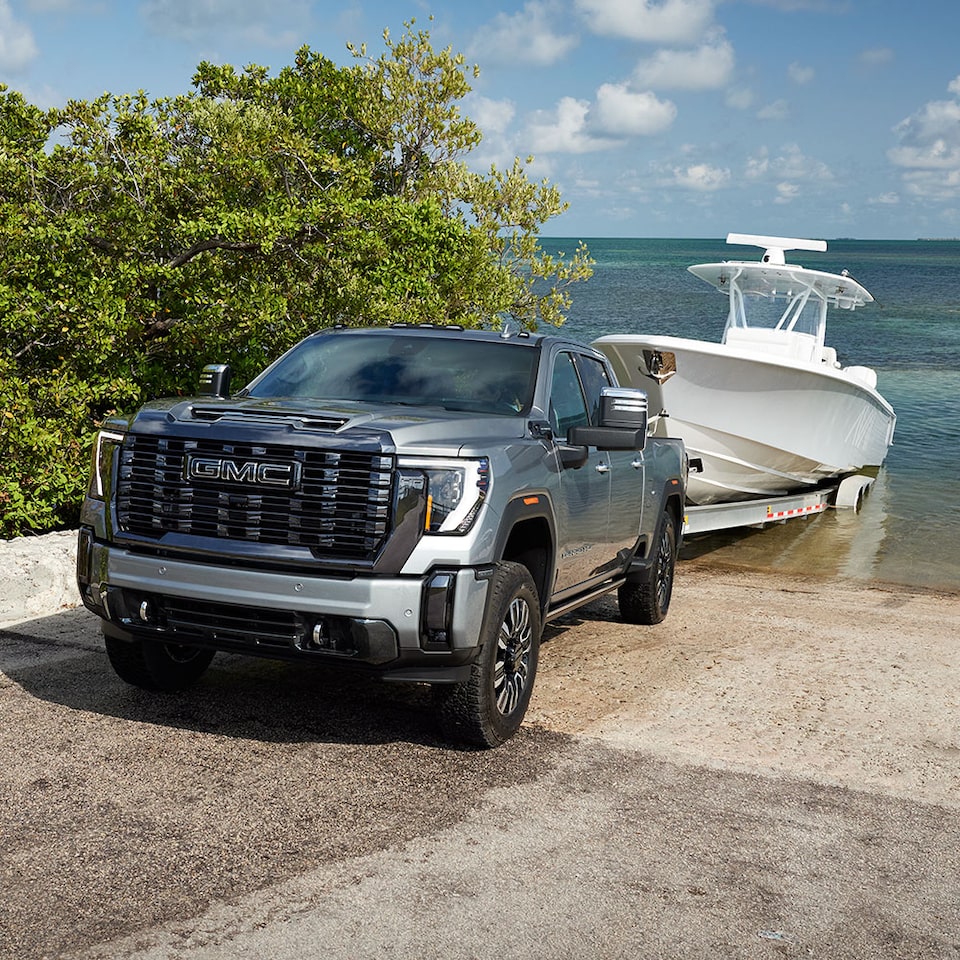 A Woman on the Beach Sitting in the Trunk of Her GMC Vehicle