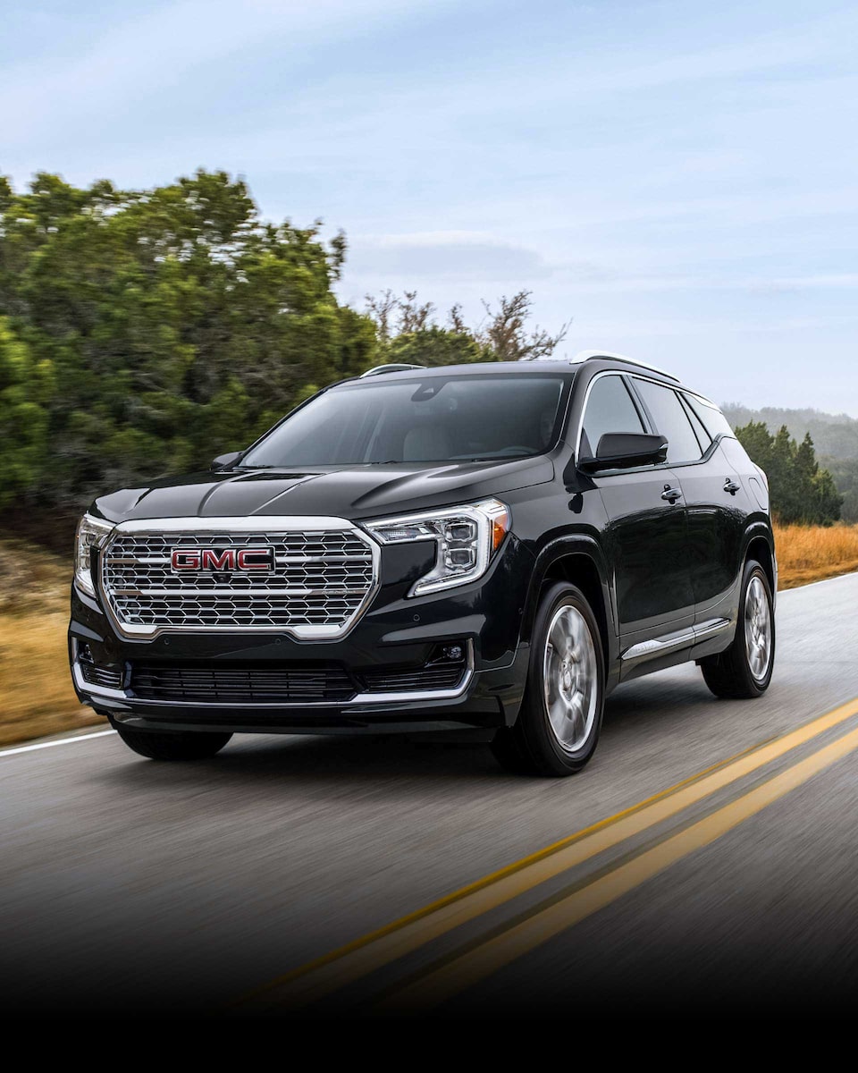 Front Three-Quarters View of a 2024 GMC Terrain Small SUV Driving on an Open Road