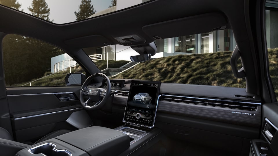 A Passengers Side View of the Interior on the GMC Sierra EV Parked With House in Front