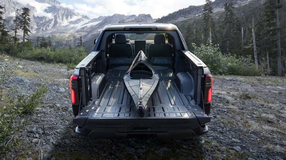 A kayak being stowed on the truck bed of the 2025 GMC Sierra EV Denali.